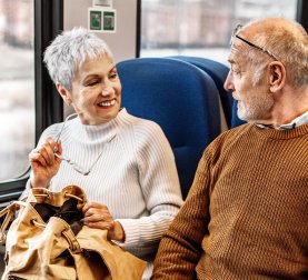 Jahresbericht 2024 Älteres Paar sitzt im Zug Bahn Mobilität
