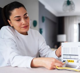 Jahresbericht 2024 Frau mit WLAN-Router Internet Netzwerk Digitales