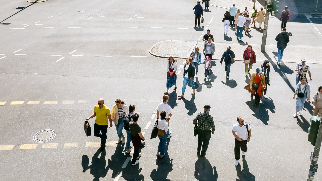 Viele Menschen laufen über eine Kreuzung in der Stadt