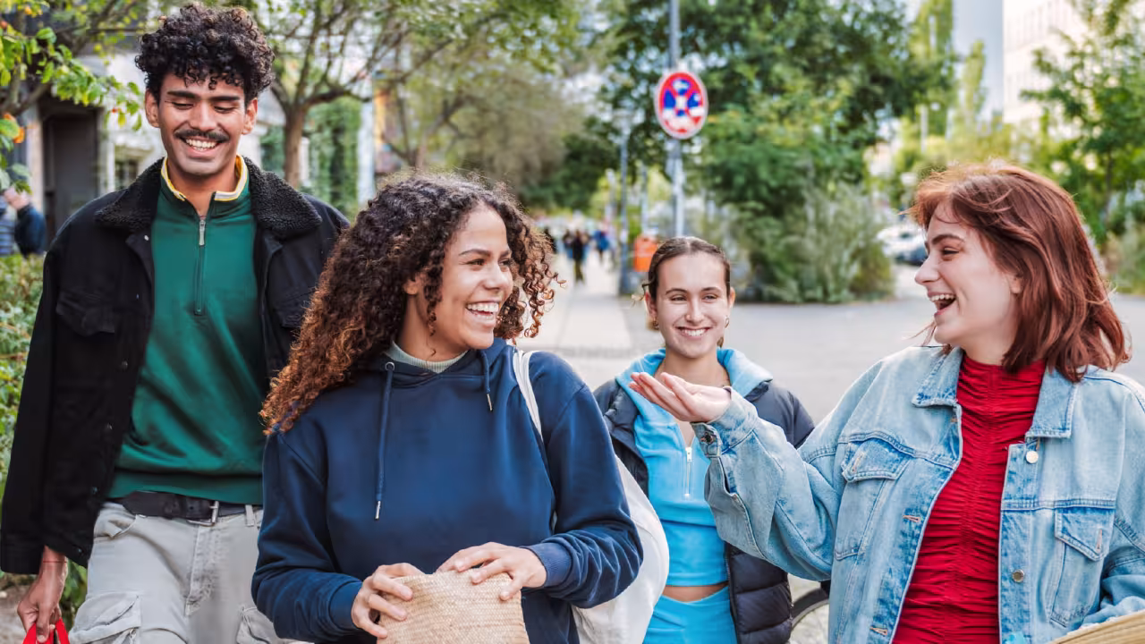 Eine Gruppe von Jugendlichen läuft fröhlich durch die Straße.
